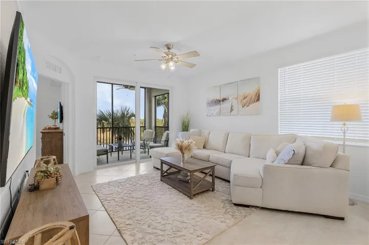 Living room with ceiling fan and light tile patterned floors