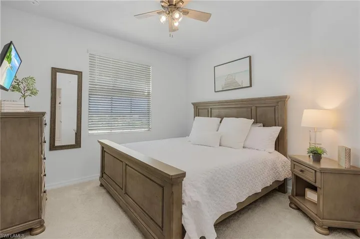 Carpeted bedroom with ceiling fan