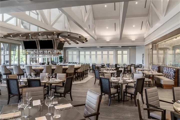Dining space with wood finished floors, a towering ceiling, beamed ceiling, and recessed lighting