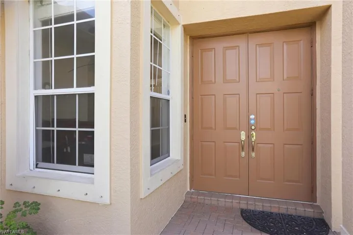 Doorway to property featuring stucco siding