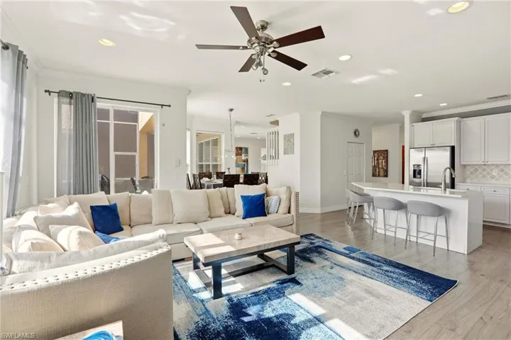 Living room featuring ornamental molding, recessed lighting, light wood-style floors, and a ceiling fan
