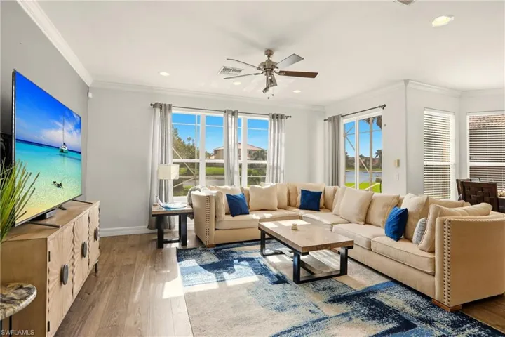 Living area featuring wood finished floors, ornamental molding, a ceiling fan, and recessed lighting