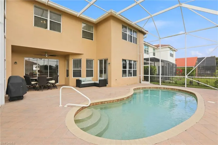 Outdoor pool with a sunroom, a patio area, a lanai, area for grilling, and an outdoor hangout area