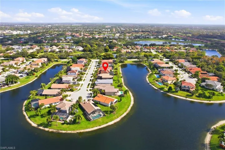 Aerial view of property's location with a nearby body of water and nearby suburban area