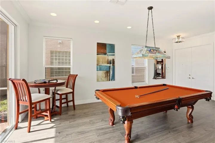 Rec room with billiards, wood finished floors, ornamental molding, and recessed lighting