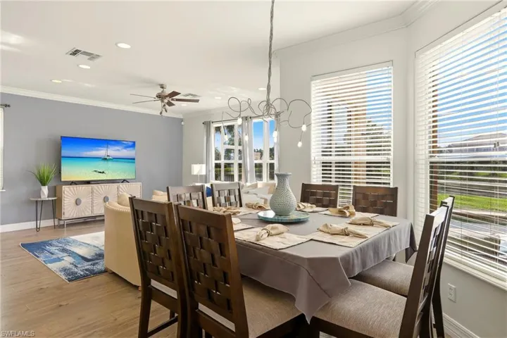 Dining room with crown molding, wood finished floors, recessed lighting, and ceiling fan