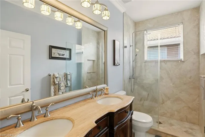 Full bathroom with a marble finish shower and double vanity