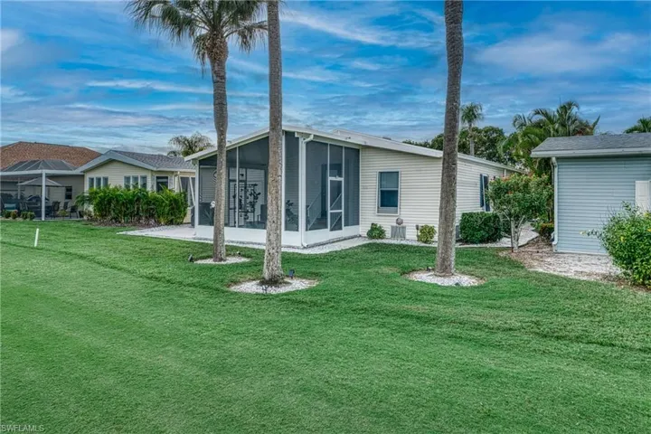 Back of property featuring a sunroom and a yard