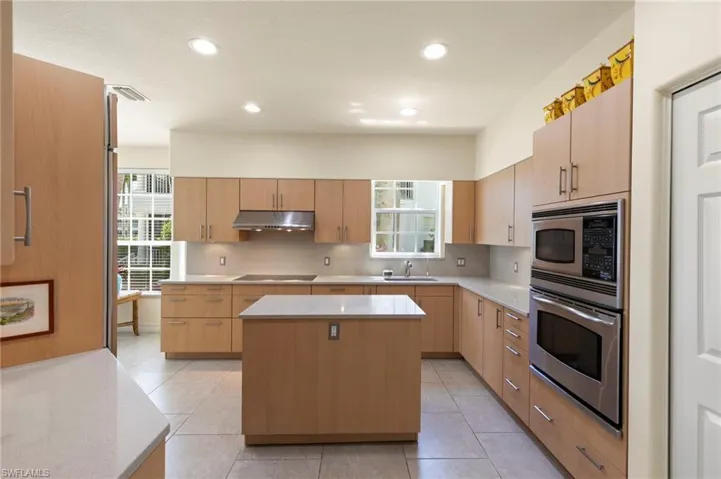 Kitchen featuring light wood-finish cabinetry, stainless steel appliances, a center island with countertop, and recessed lighting