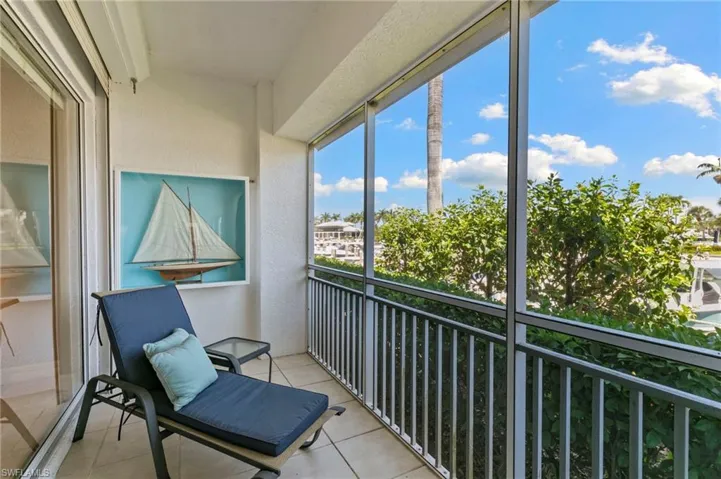 Screened balcony featuring textured exterior walls and light-toned tile flooring