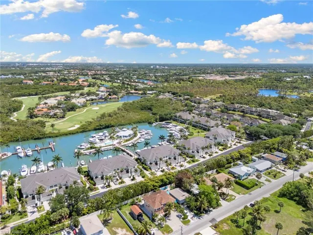 Waterfront residences featuring private boat slips, mature palm trees, a canal, and proximity to a golf course