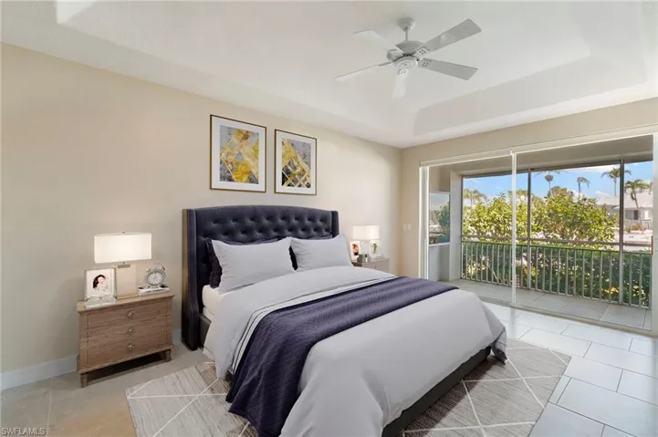 Room featuring tray ceiling, ceiling fan, and tile flooring