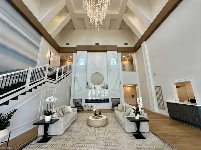 Grand foyer featuring soaring ceilings with exposed beams and a tiered crystal chandelier
