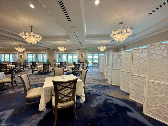Spacious event room featuring a patterned blue and white area rug, decorative room dividers, and multiple chandeliers