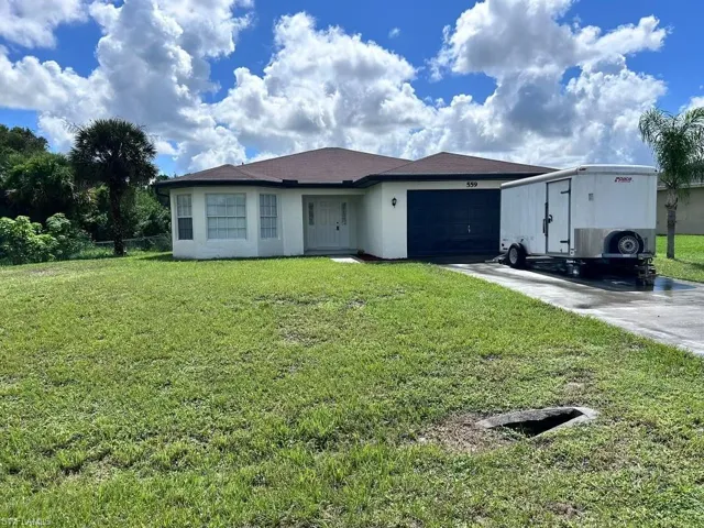 View of front facade featuring a garage and a front yard
