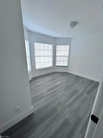 Empty room featuring dark hardwood / wood-style floors and a wealth of natural light