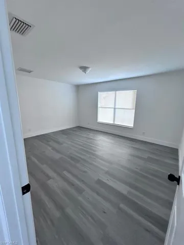 Unfurnished room with dark wood-type flooring