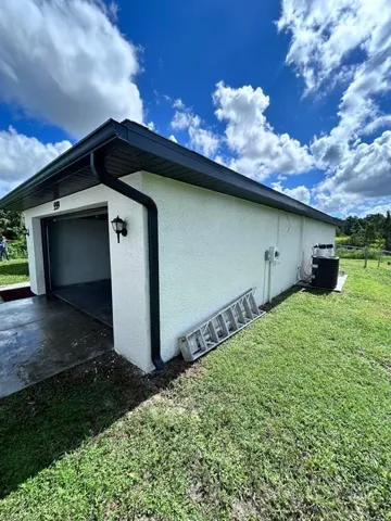 View of home's exterior featuring central AC and a lawn