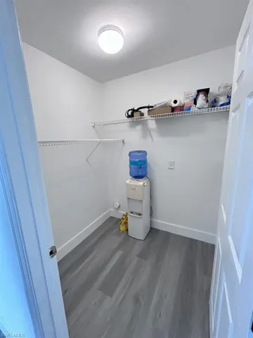 Clothes washing area featuring dark hardwood / wood-style flooring