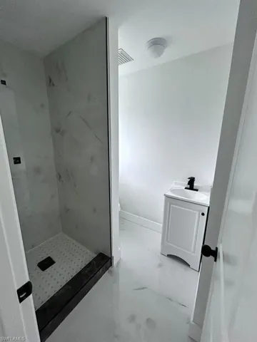 Bathroom with vanity and tiled shower