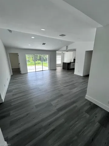 Unfurnished living room featuring dark hardwood / wood-style floors and sink