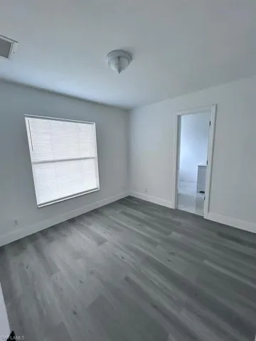 Unfurnished room featuring dark wood-type flooring