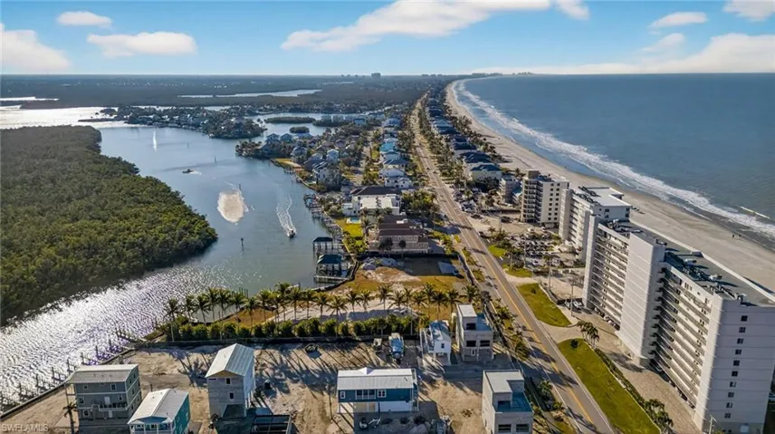 Aerial perspective of coastal property situated between an inlet and the Atlantic shoreline, featuring direct water access and proximity to sand beaches