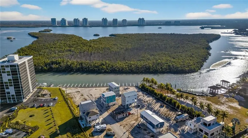 Waterfront parcel featuring direct canal access, established palm tree landscaping, and surrounding coastal scenery