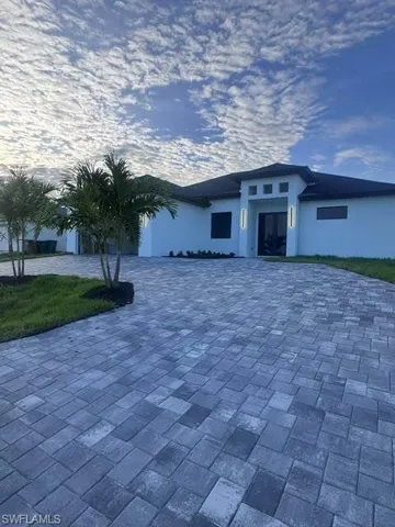 Contemporary stucco exterior featuring a dark tiled roof