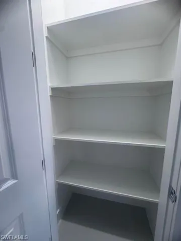 Built-in shelving unit featuring multiple white shelves and white interior walls