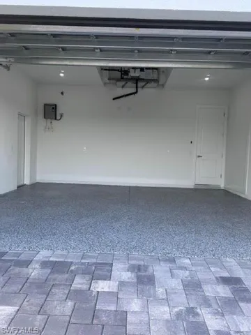 Garage interior featuring a speckled epoxy floor coating and recessed lighting
