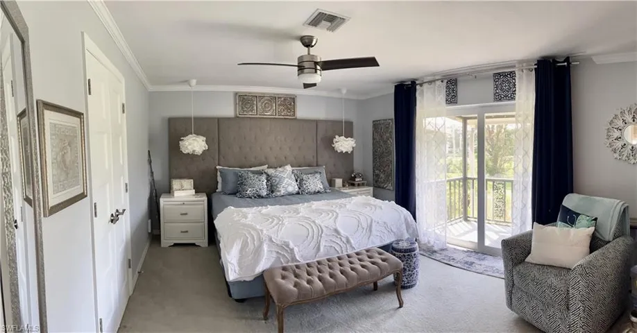 Primary Bedroom with King Bed, ensuite bathroom, carpet floors, access to balcony, sitting area with dresser and TV