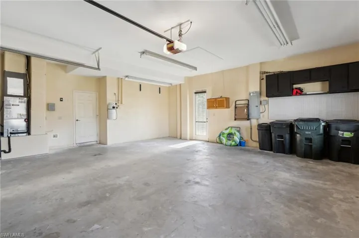 Garage featuring electric panel and a garage door opener