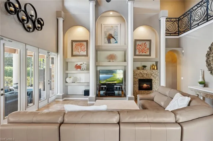 Living room with built in features and a towering ceiling