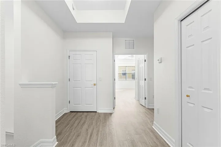 Hallway featuring light wood-style flooring and baseboards