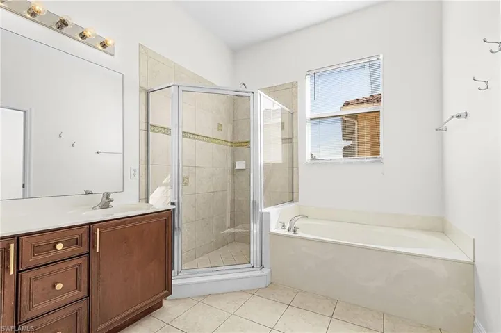 Full bathroom with a garden tub, a shower stall, light tile patterned flooring, and vanity