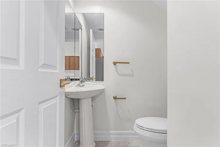 Half bath with toilet and light tile patterned floors