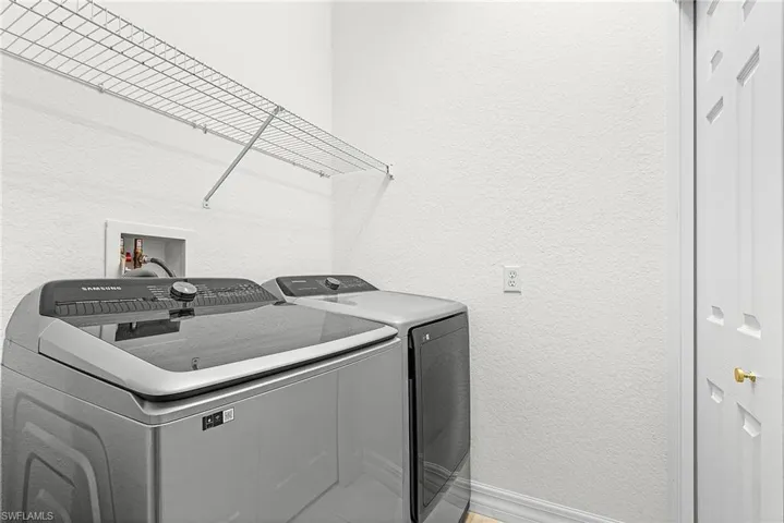 Laundry room with a textured wall and washer and dryer