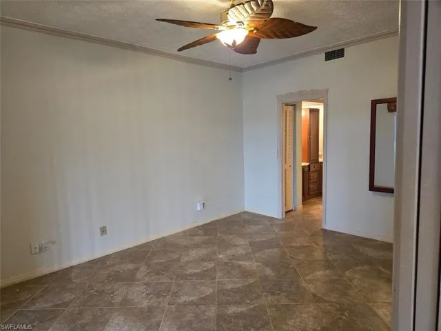 master bedroom with a textured ceiling, ornamental molding, and a ceiling fan