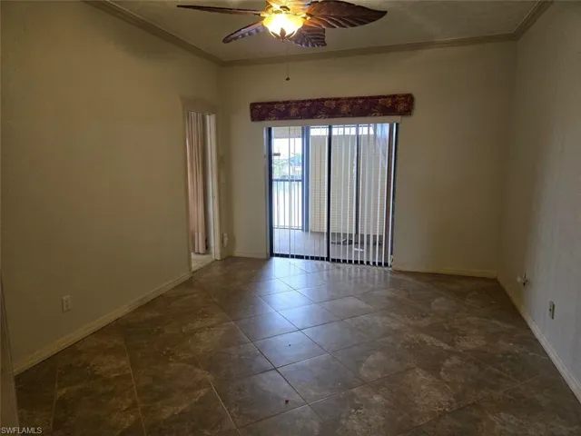 Master bedroom featuring ornamental molding, ceiling fan, and dark tile patterned floors