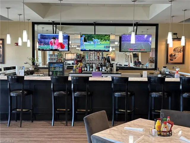 Community bar area featuring decorative light fixtures and dark cabinets