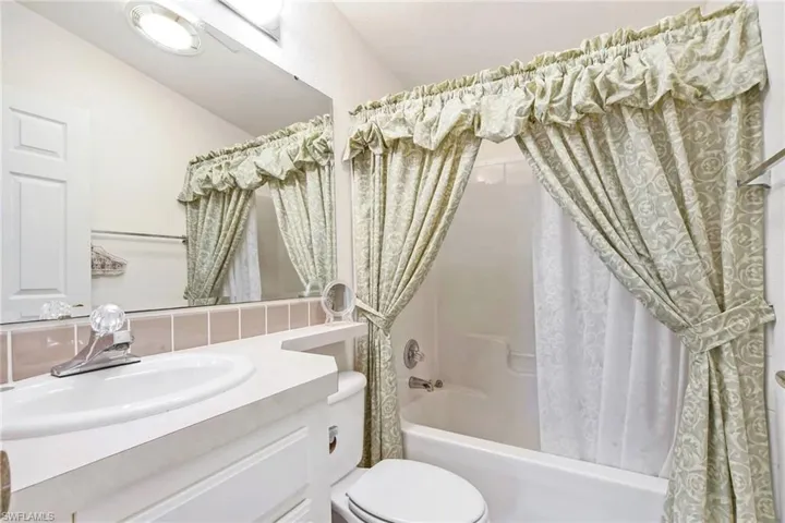 Full bath featuring shower / bathtub combination with curtain and vanity