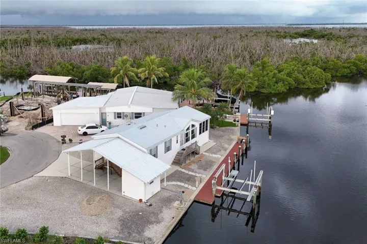 Drone / aerial view of a nearby body of water and a heavily wooded area