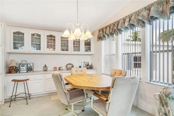 Dining area with a chandelier and light colored carpet