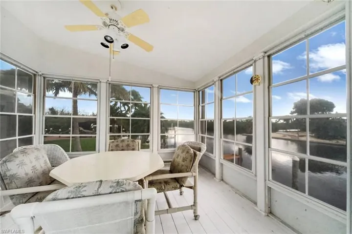 Sunroom / solarium featuring plenty of natural light, a water view, vaulted ceiling,