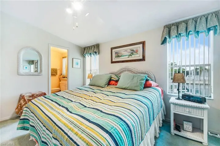 Carpeted bedroom featuring a ceiling fan and connected bathroom