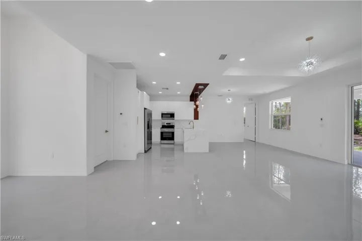 Unfurnished room featuring baseboards, a chandelier, recessed lighting, a sink, and light marble finish flooring