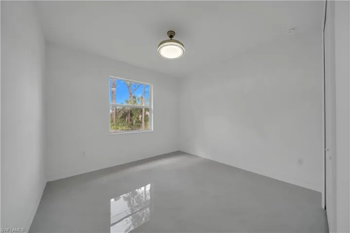 Spare room with baseboards and concrete flooring