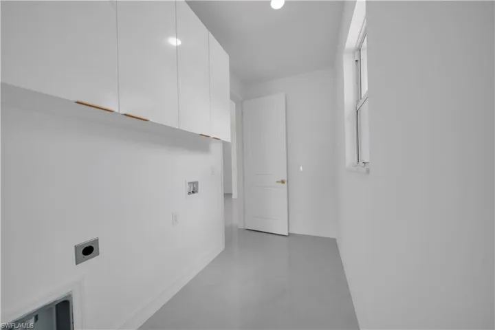 Washroom with hookup for an electric dryer, cabinet space, baseboards, and washer hookup