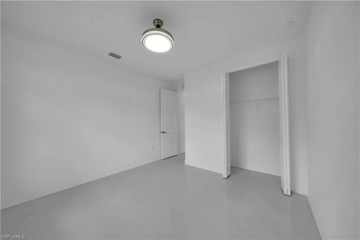 Unfurnished bedroom featuring a closet, light tile patterned flooring, and baseboards